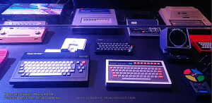 vitrine exposant d'anciennes consoles et claviers de jeux vidéo au salon Videogame Story